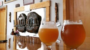 A bar with wooden stools and a chalkboard sign reading "Welcome Stumptown Ales". - Davis, WV 2BR full kitchen NR Stumptown Ales (Davis)