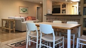A modern living room with a dining area, a sofa, a coffee table, and a TV. - Private Marina, Docks, Close to Golf Course, Restaurants. (Parker)