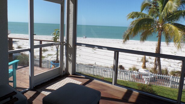 Ein Balkon mit Blick auf Strand und Meer.