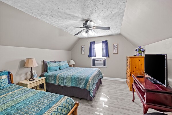 A bedroom with two beds, a ceiling fan, a dresser, a TV, and a window with curtains. - Lakefront/Boat Dock, 3/2, Furnished, Castaway Cottage, covered back deck views (Lexington)