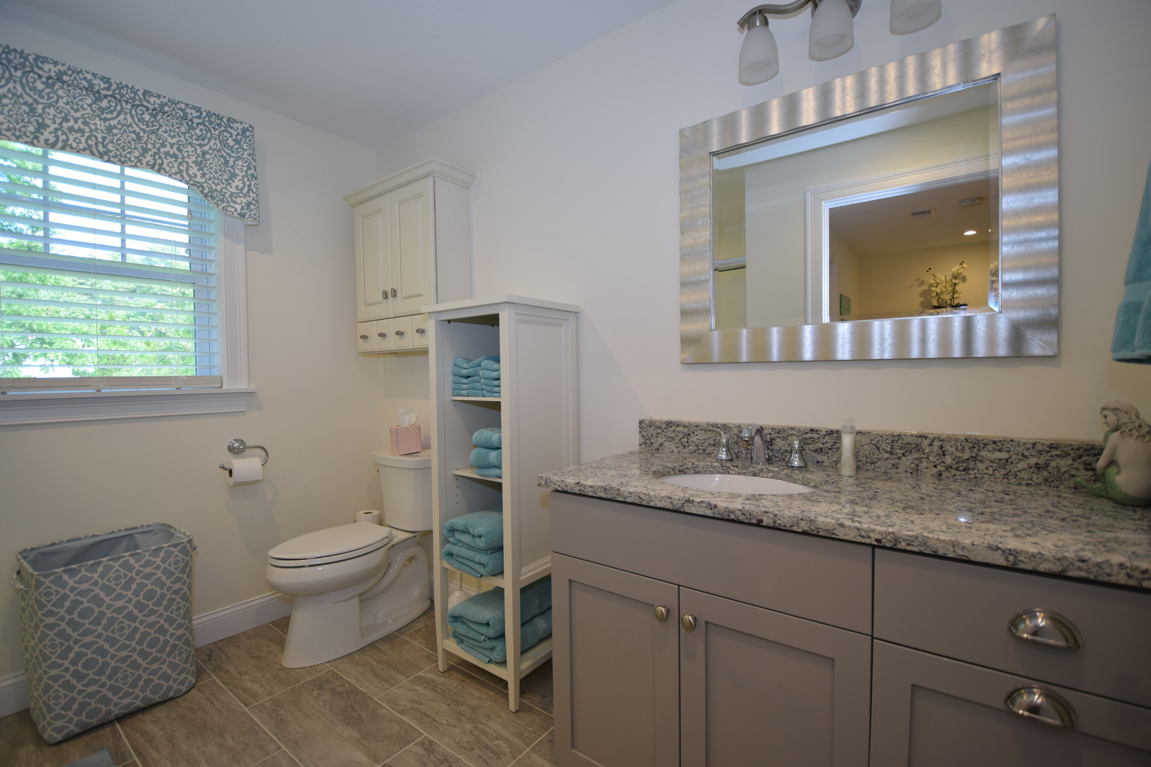 Ein Badezimmer mit Toilette, Waschbecken, Spiegel und Handtuchhalter.