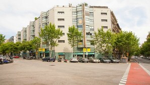 Un edificio de varios pisos con un estacionamiento al frente.