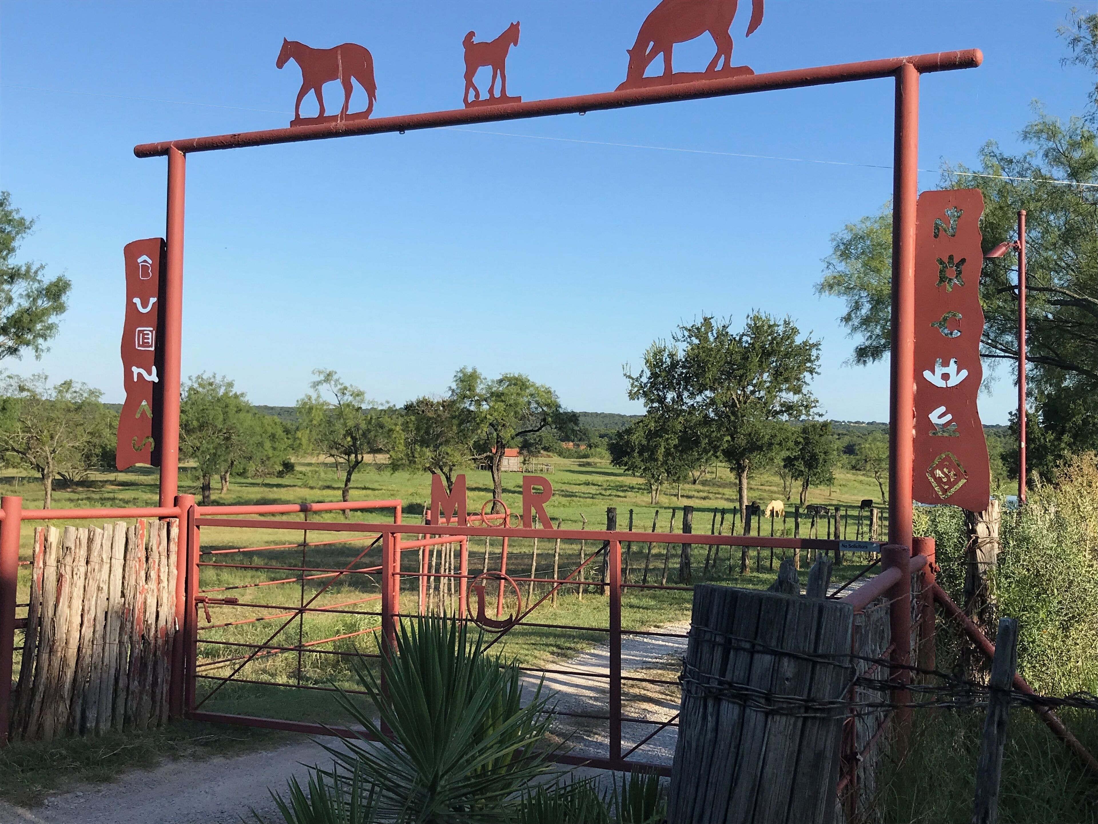A rustic gate with animal silhouettes and a sign that reads "MOR."