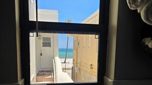 Ein Fenster mit Blick auf ein Gebäude und einen Strand.