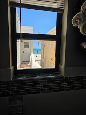 A window with a view of a building and a beach.