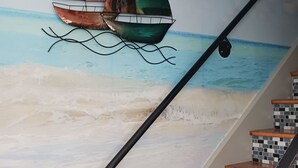 Eine Treppe mit einem Fliesenmosaik und einem Wandgemälde mit Segelbooten.