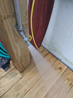 Una terraza de madera con una tubería de metal y una línea amarilla que la delimita.