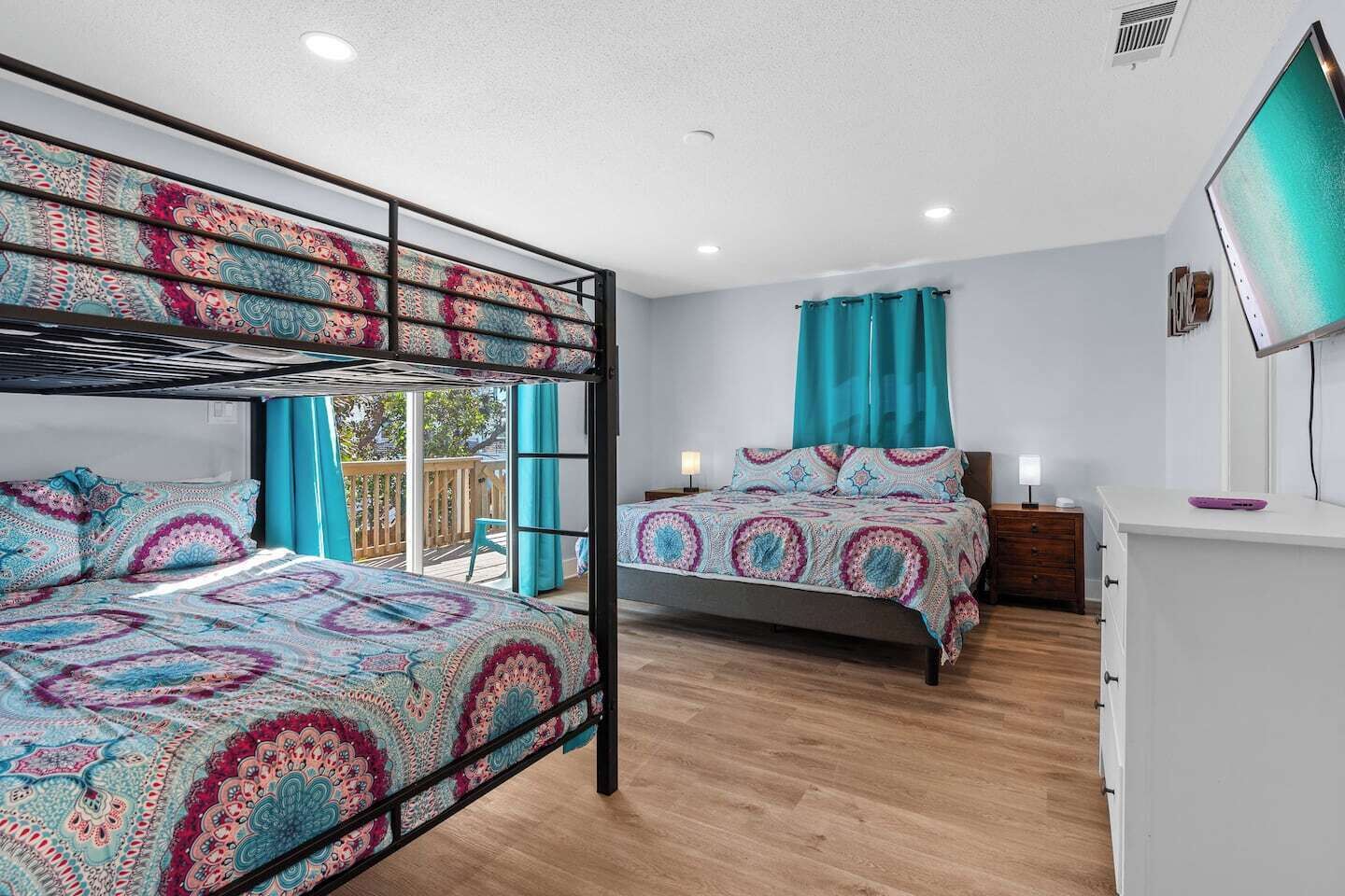 Ein Zimmer mit Etagenbetten, einem Schreibtisch und einem Fernseher.