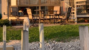 En tvåvåningsbyggnad med en balkong, ett utomhusområde med sittplatser och en spiraltrappa.