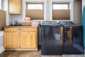 Un espace buanderie avec des armoires en bois, un lave-linge et un sèche-linge.