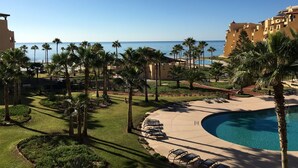 Ein Resort mit Pool, Palmen und Meerblick.