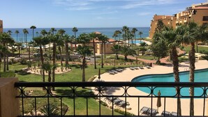 Ein Resort mit Pool, Palmen und Meerblick.