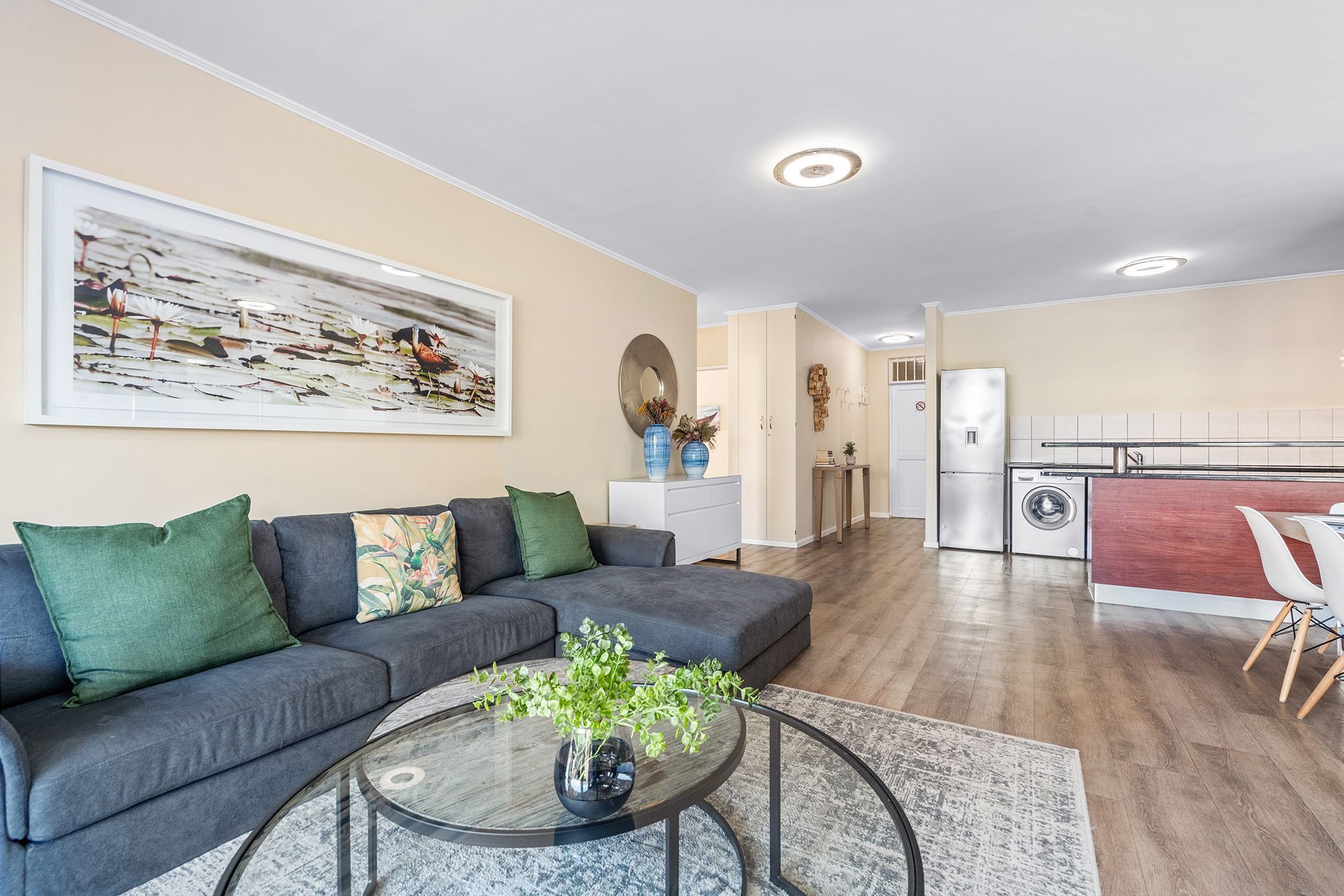 Een moderne woonkamer met een bank, een salontafel en een schilderij aan de muur.