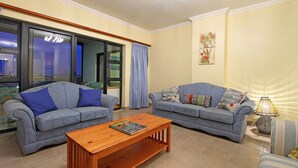 A living room with two sofas, a wooden coffee table, and a lamp. - Knightsbridge 407 (Cape Town)