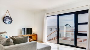 Una sala de estar moderna con un sofá, un televisor y un reloj de pared.