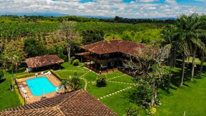 A large villa with a swimming pool, surrounded by lush greenery and palm trees. - Finca Hotel El Palmar (Montenegro)