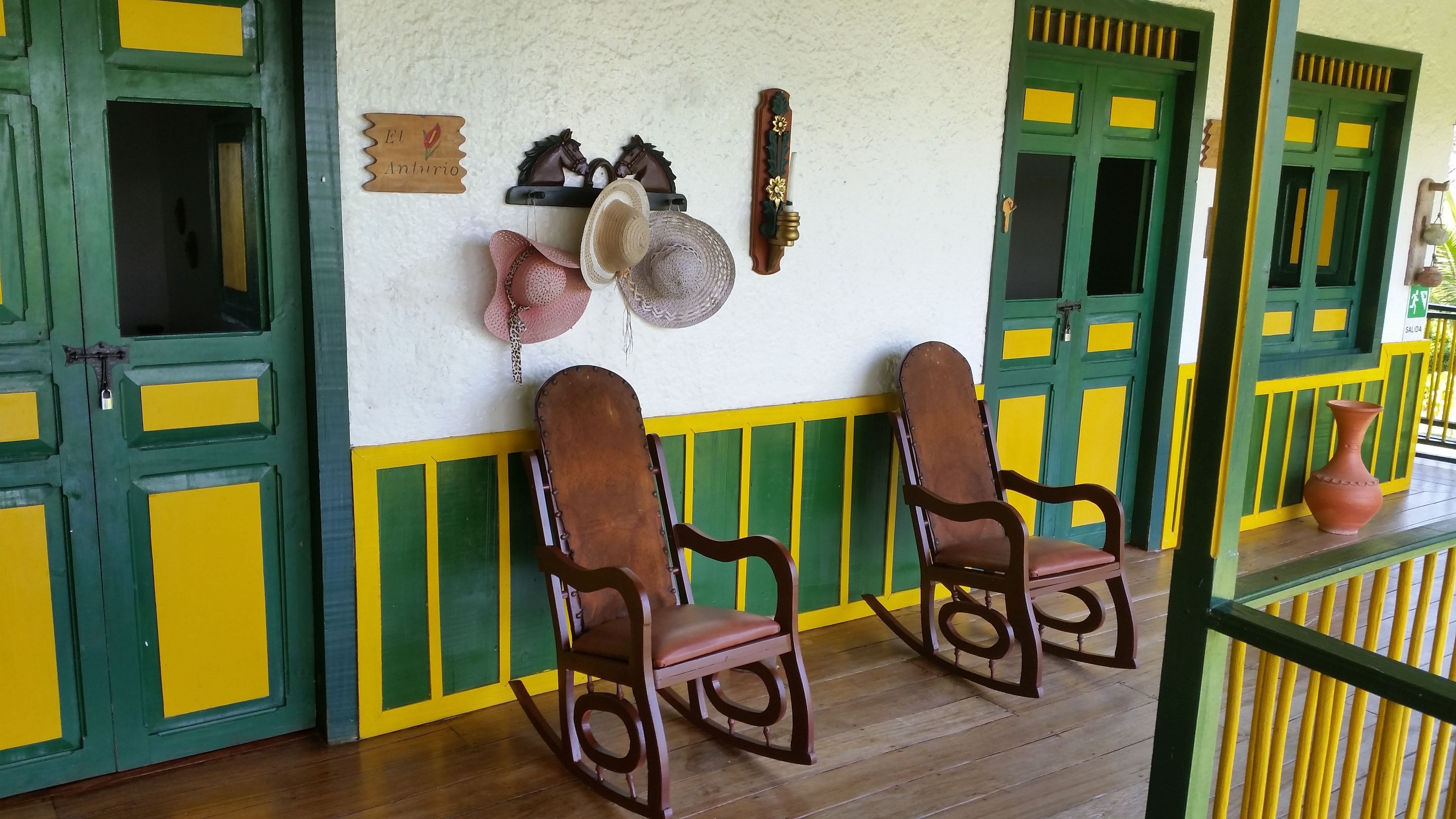 Une pièce avec deux fauteuils à bascule, un porte-chapeaux fixé au mur et une porte dotée d’une serrure.