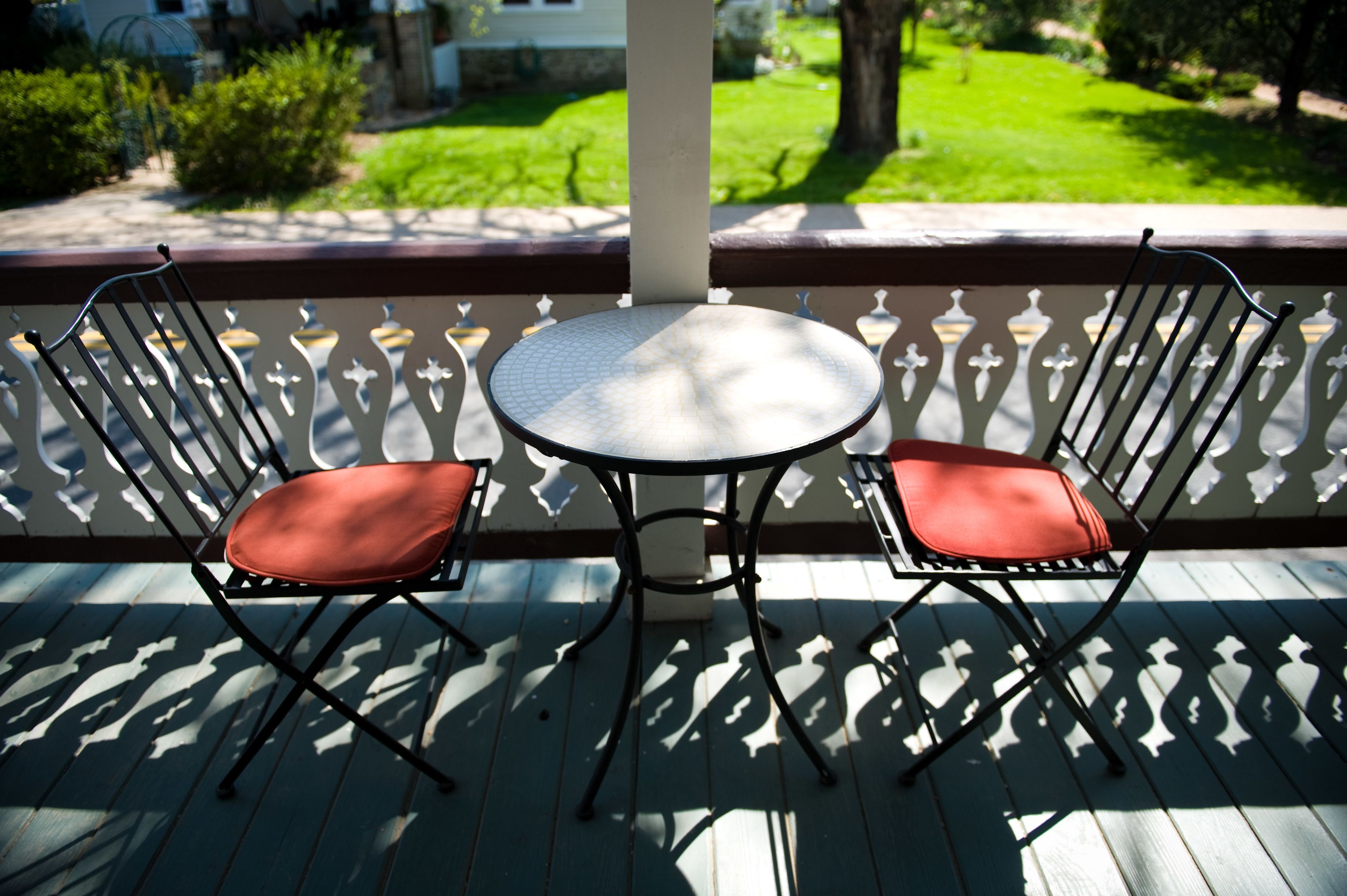 A wooden deck with a round table and two chairs.