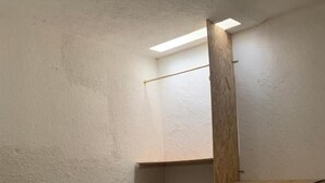 Una habitación con escritorio, sillas y una estantería de madera.