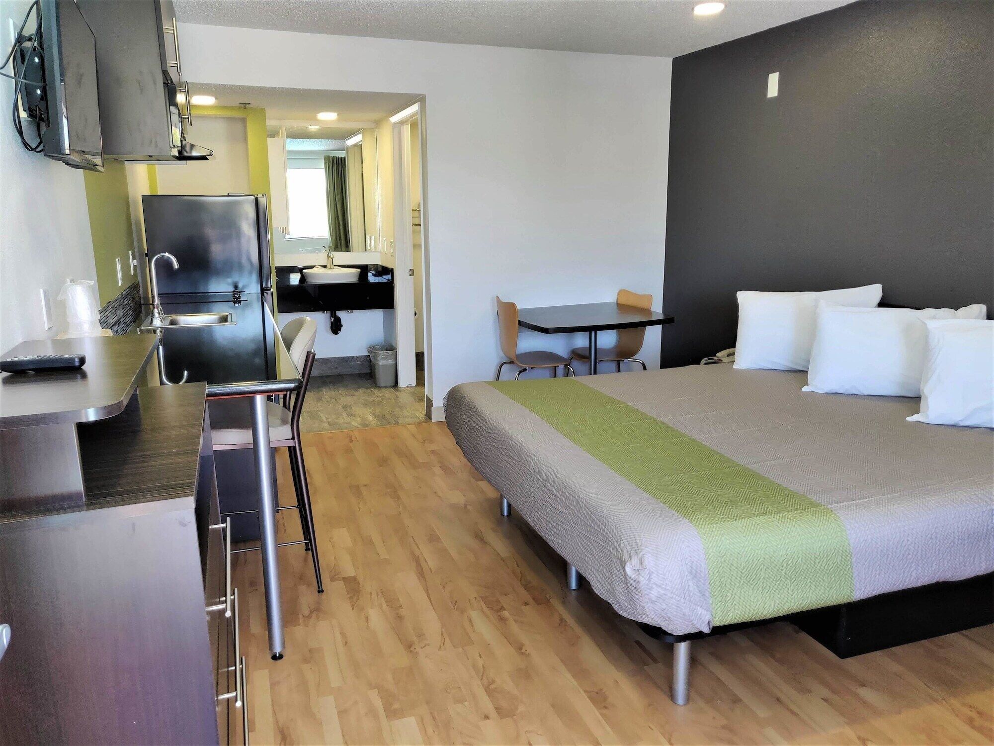 Une chambre d’hôtel avec un lit, un bureau, une chaise, une télévision et une salle de bain.