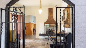 An arched doorway leading into a room with a fireplace, a dining table, and chairs. - Brigham House (Tooma)