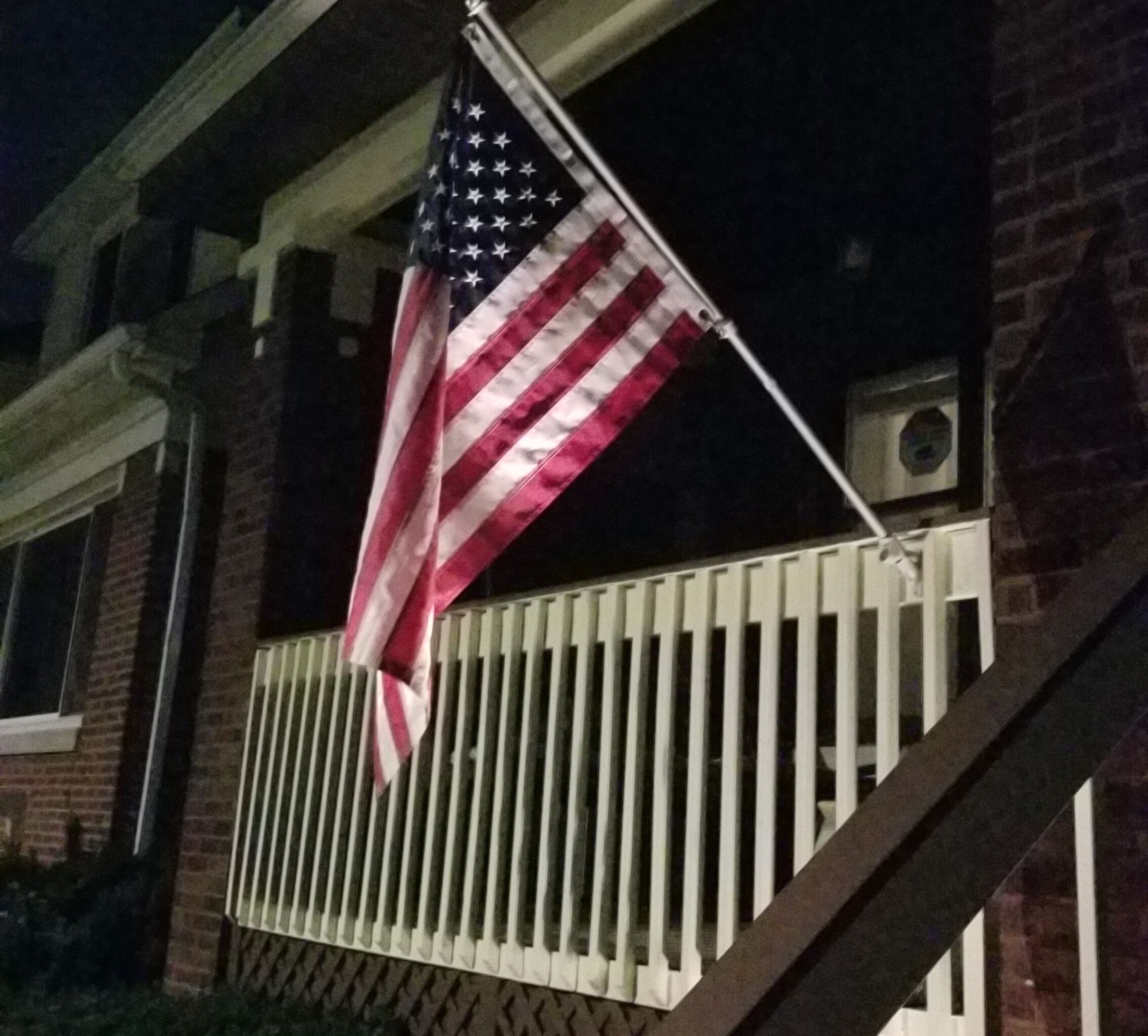 An American flag on a balcony railing.