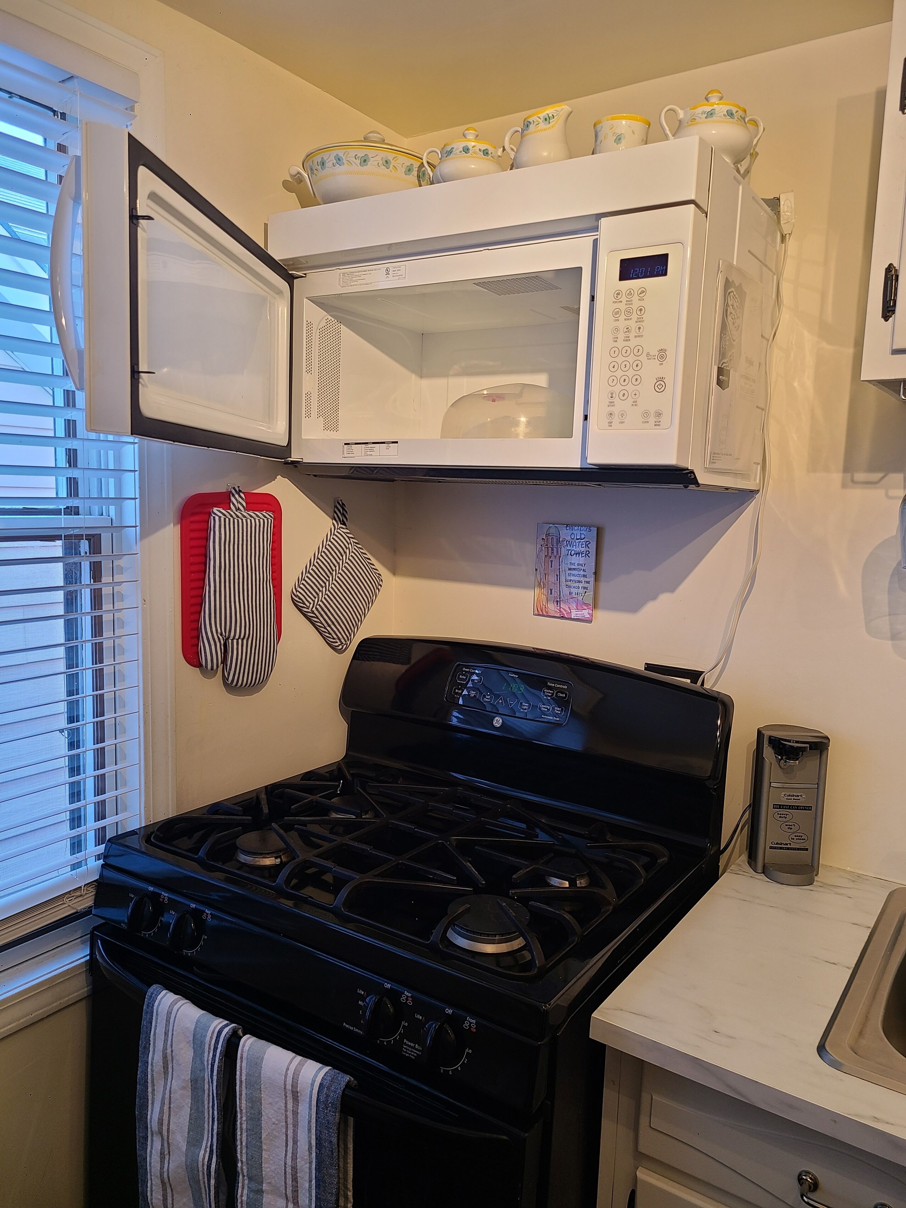 A kitchen with a stove, microwave, and a gas range.