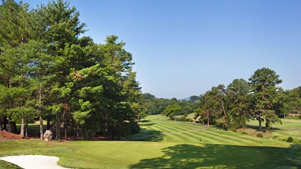 A golf course with a sand bunker, trees, and a clear sky. - 1 Bedroom Vacation Villa (Asheville)