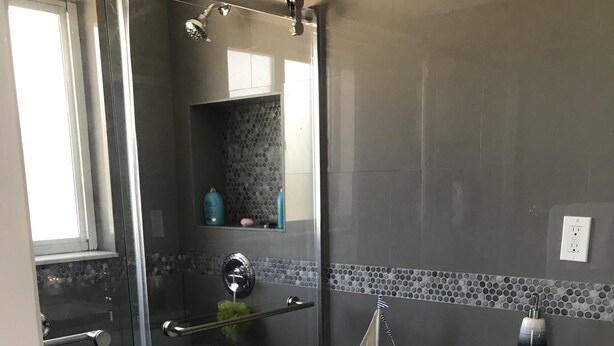 A bathroom with a glass-enclosed shower, a toilet, and a sink with a marble countertop. - Breathtaking ocean views for your Paradise vacations (Islamorada)