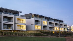 Un hôtel moderne à plusieurs étages, doté d’un toit plat, de grandes fenêtres et de panneaux solaires.