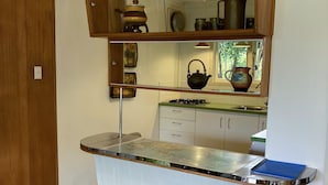 Una cocina con un armario de madera, una encimera de acero inoxidable y un suelo a cuadros.