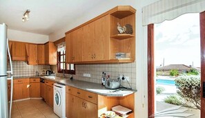 Enjoy a kitchen with washing machine and a window overlooking the pool and lush surroundings.