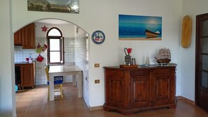 Una cocina con un armario de madera, salpicadero de azulejos y una ventana.