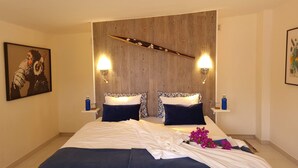 Ein Hotelzimmer mit einem großen Bett, zwei Nachttischen und einem Holzkopfende.