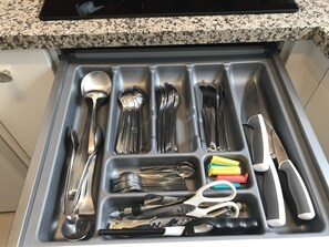 A kitchen drawer with utensils and tools.