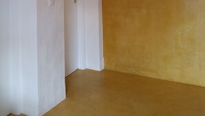 A room with a sloped ceiling, white walls, and a wooden floor. - "Casa da Charca" - SW Alentejano (Odemira)