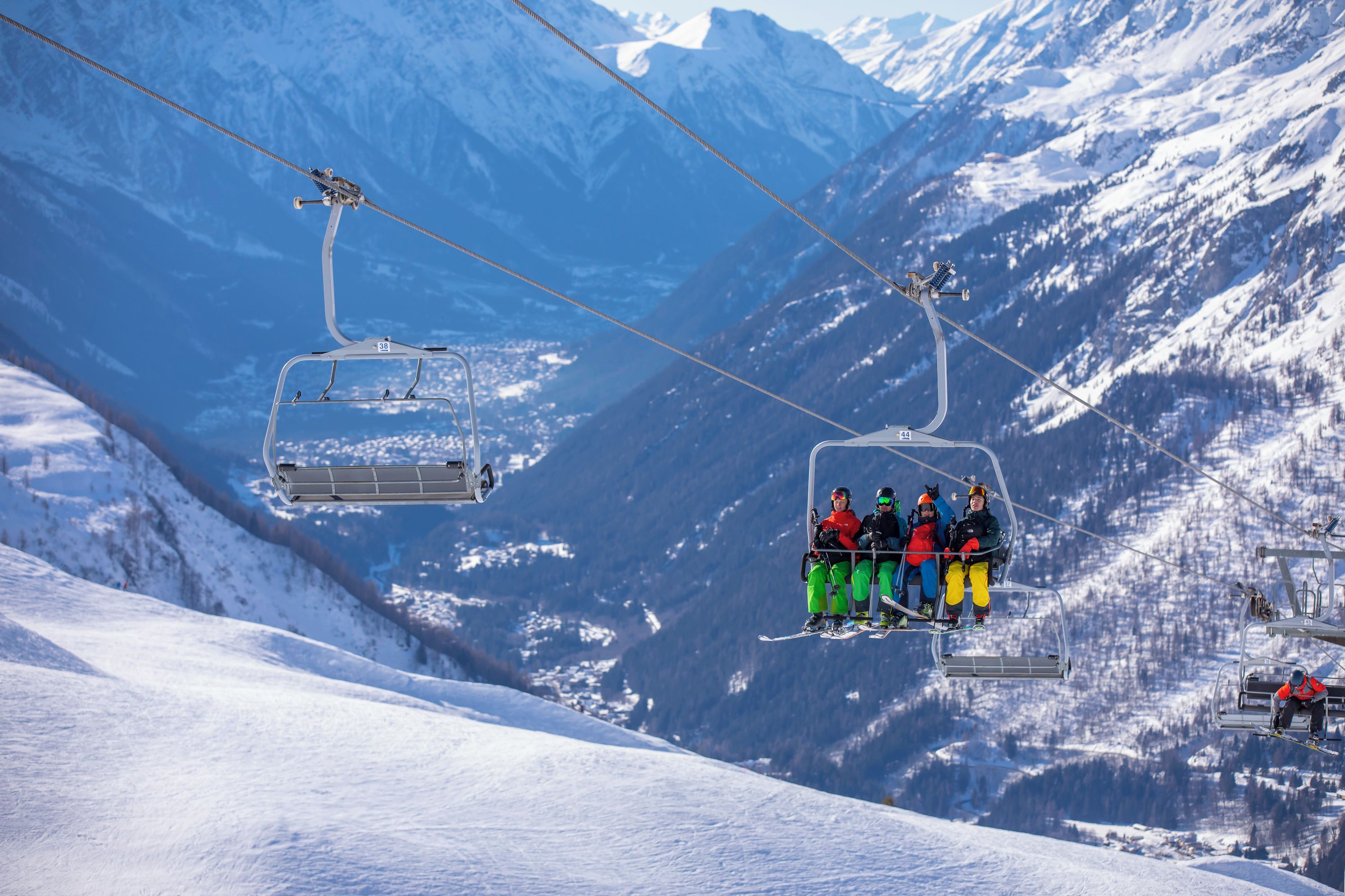 Een skilift met skiërs in opvallende kleding.