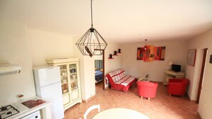 A compact living space with a kitchenette, a dining area, and a sofa.