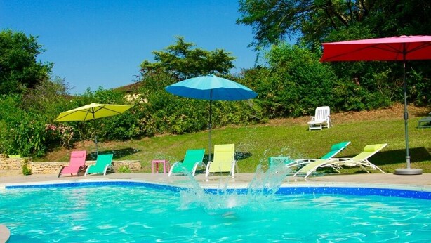 A swimming pool with colorful lounge chairs and umbrellas.
