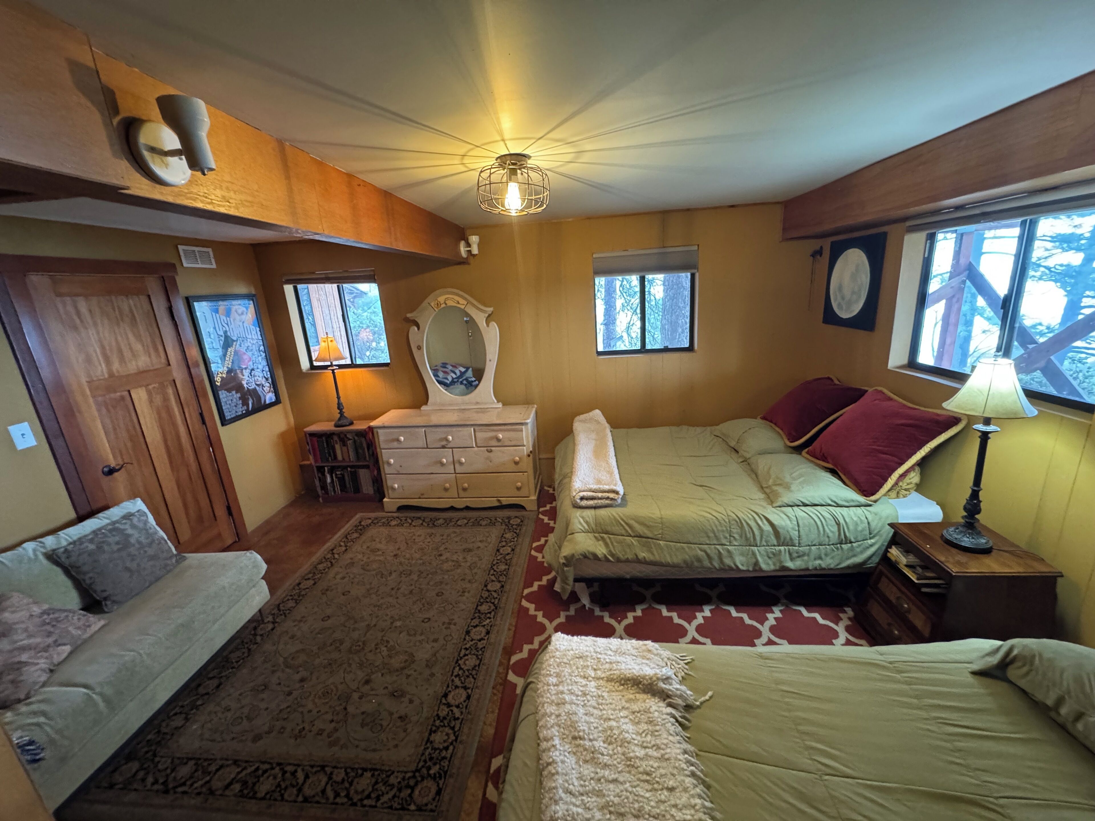 Un dormitorio acogedor con cama, cómoda, espejo, ventana y puerta.