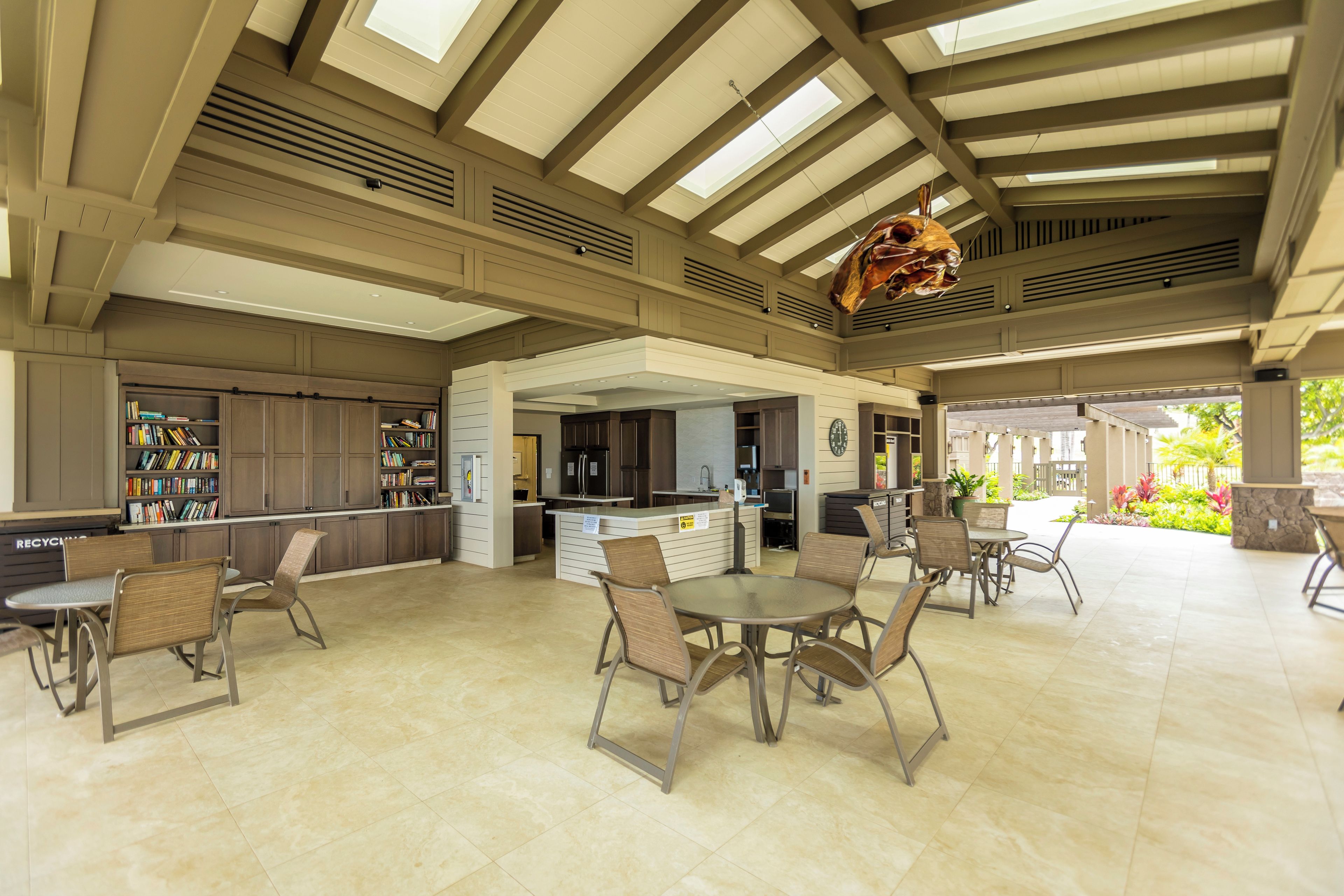 A spacious indoor area with high ceilings, a central island with a sink, and seating arrangements.