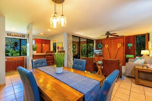 Un comedor amplio con una mesa de madera, sillas azules y un jarrón con plantas verdes.