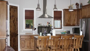A kitchen with wooden cabinets, a stainless steel refrigerator, and pendant lighting. - Private 36-Acre Ranch Near Austin & Dripping Springs - Pond & Fire Pit (Driftwood)