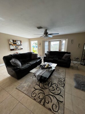 Relax in this stylish living room with two comfortable sofas, a glass coffee table, and a unique piece of art.