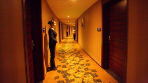 Ein Hotelgang mit Holztüren, Teppichboden und einem Schild, das Zimmer Nummer 816 anzeigt.