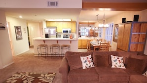 A living room with a brown sofa, a wooden coffee table, and a patterned rug.
