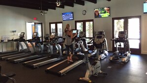 A gym with treadmills, stationary bikes, and elliptical machines.