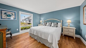 A bedroom with a large bed, two bedside tables, a window, and a door. - Waterfront Beach Club Villa! 3 BR/3.5 BA! Luxury, Ocean view! Amenity access included! (Seabrook Island)
