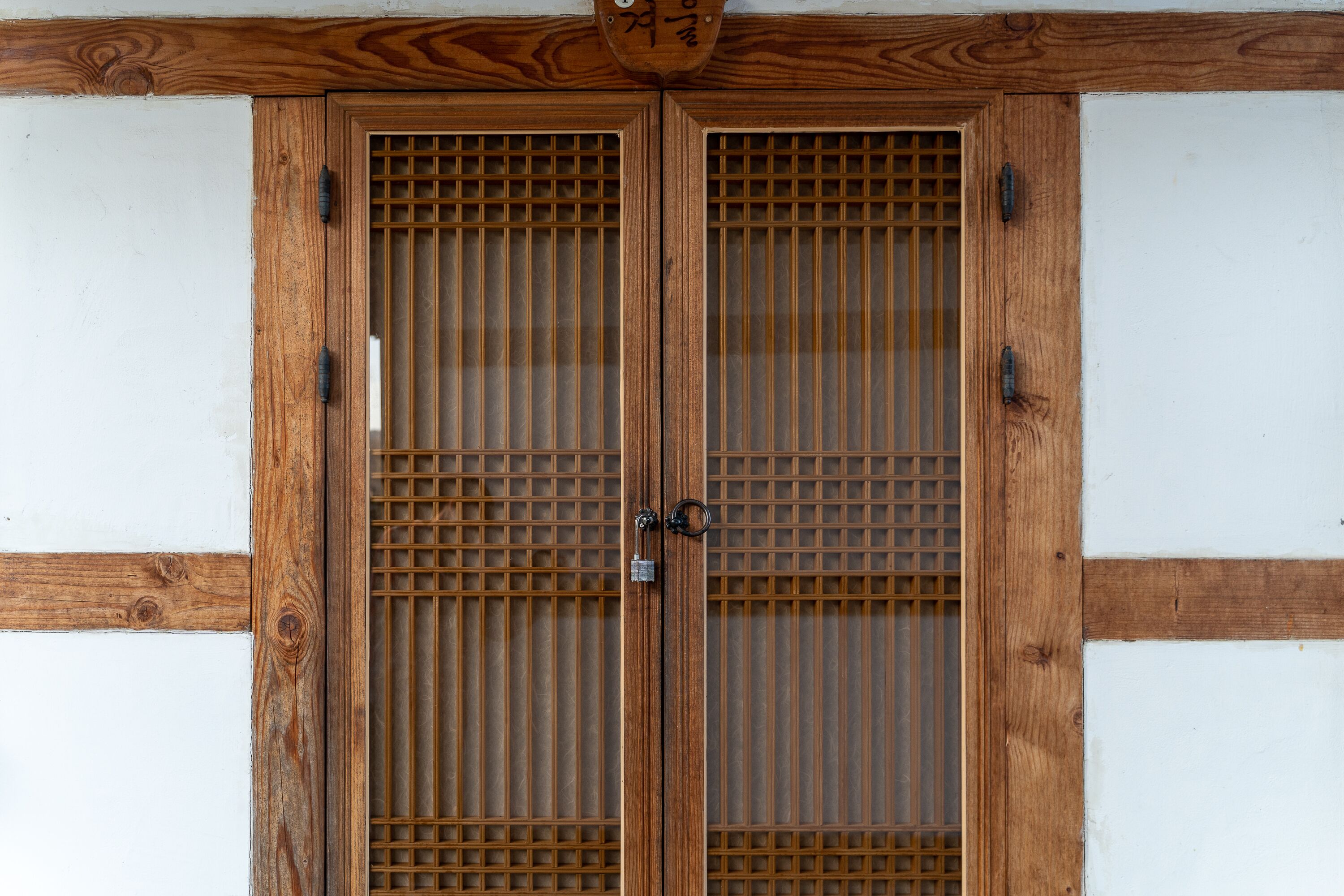 A traditional wooden door with a grid pattern and a padlock.