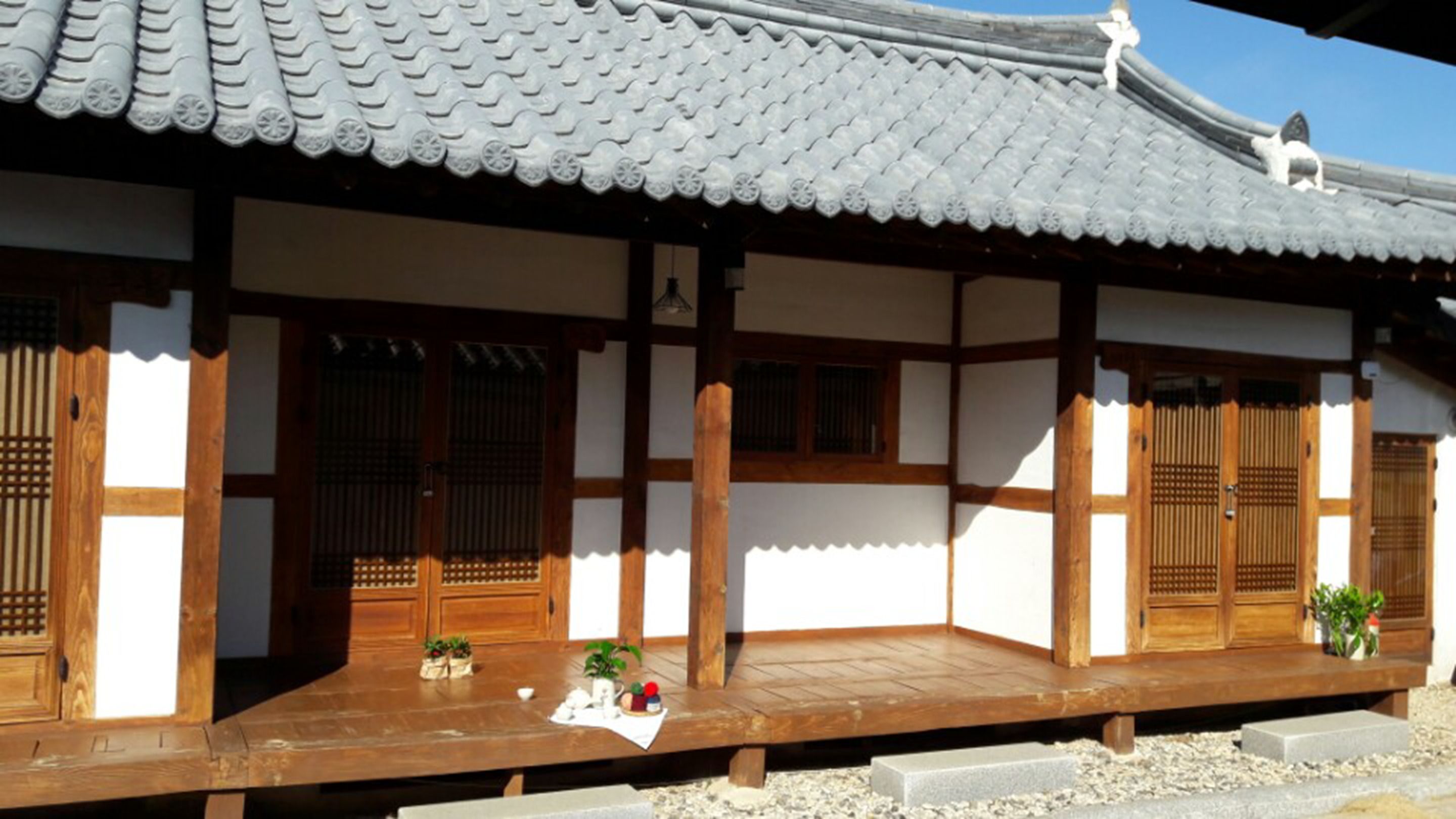 A traditional Japanese building with a tiled roof, wooden beams, and sliding doors.